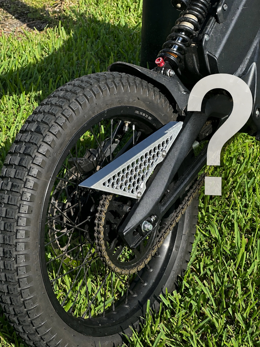 Mystery Chain Guard - X3A 3D-printed honeycomb chain guard fitted to an electric dirt bike, with a question mark overlay indicating the design is a surprise