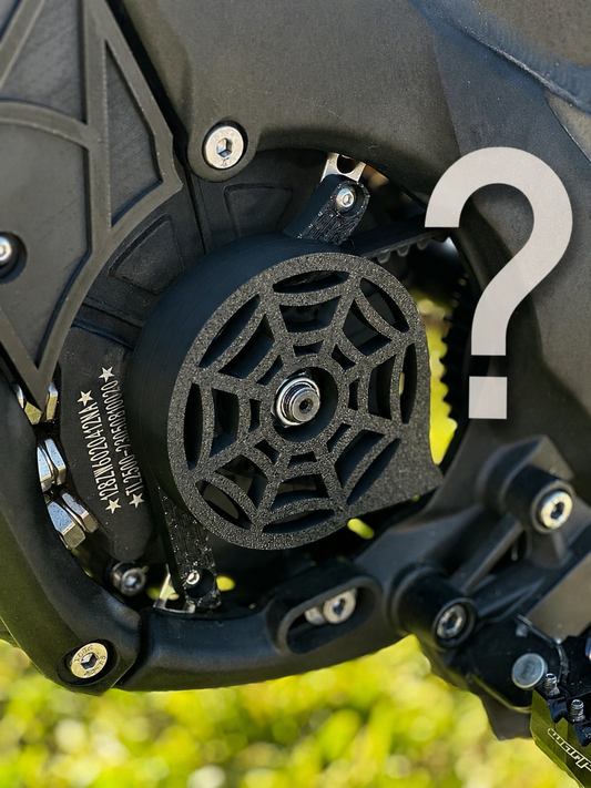 Mystery Motor Cover - X3A 3D-printed spiderweb-pattern motor cover fitted to an electric dirt bike, with a question mark overlay indicating the design is a surprise